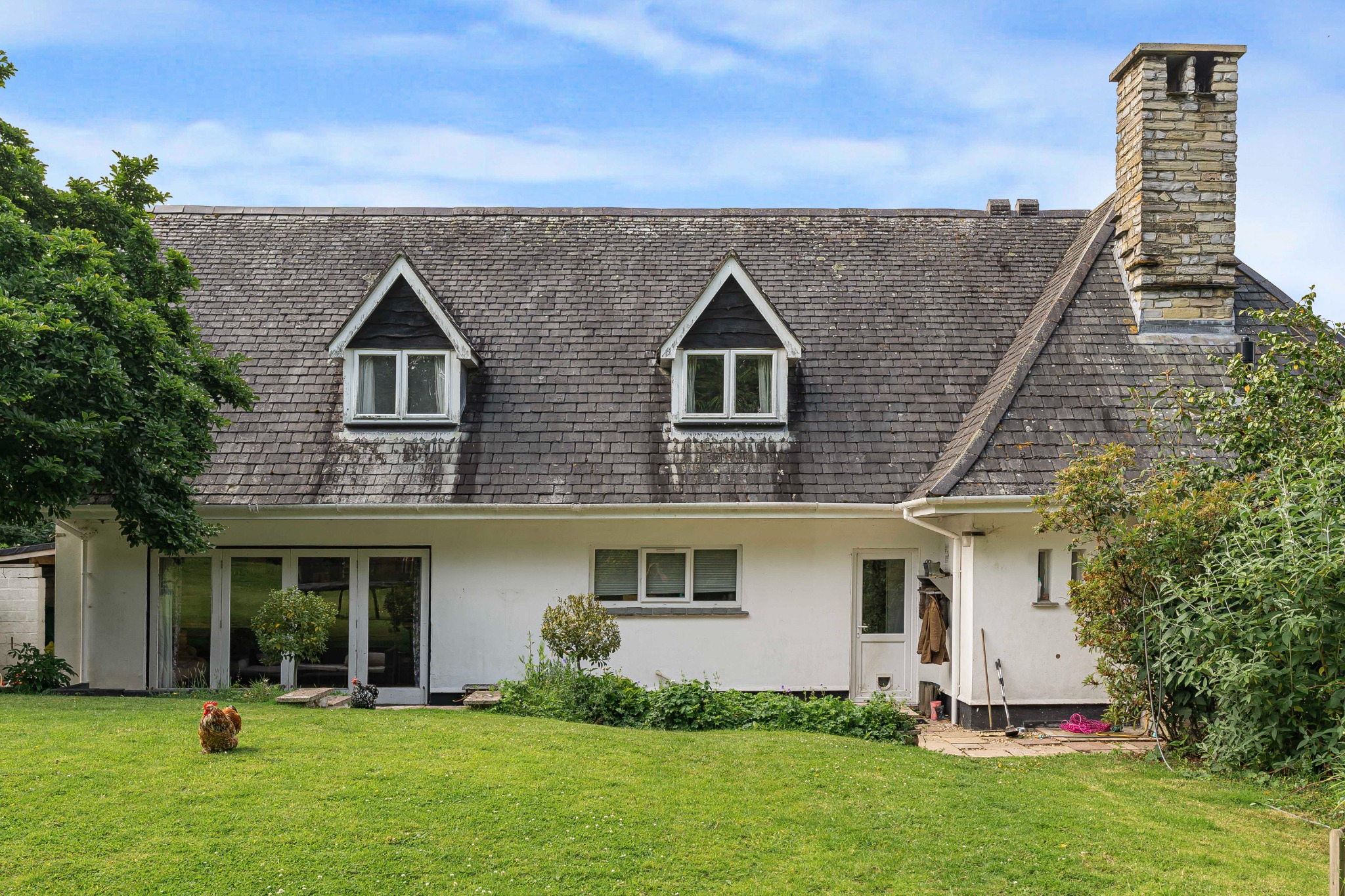 A country home with dormer windows and a garden