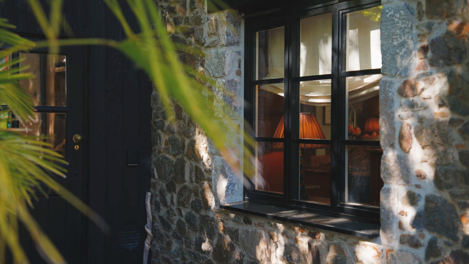 Window detail framed by stonework and planting